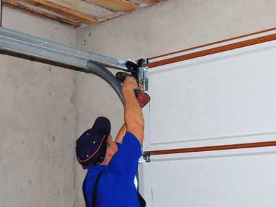 man repairing noisy garage door
