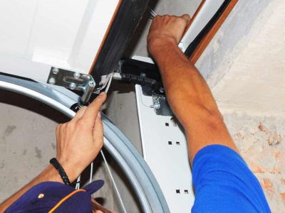 man repairing overhead garage door